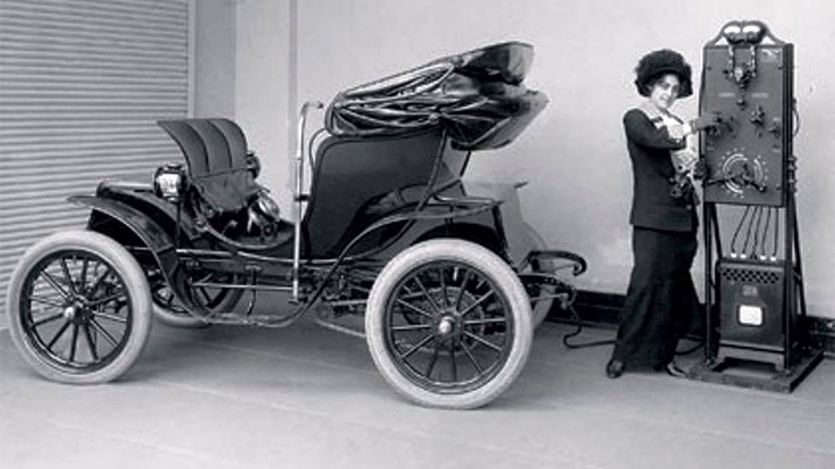 Дама в гараже заряжает свой фешенебельный электромобиль Columbia Victoria Mark 68. 1912 год, США